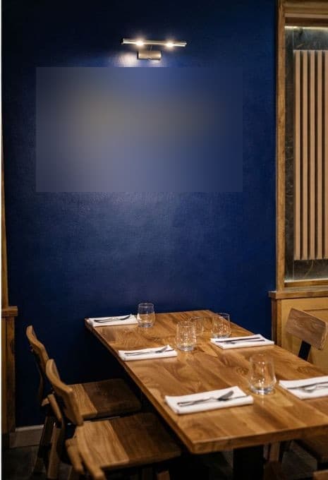 The gold wine-glass wordmark on the cobalt dining-room wall